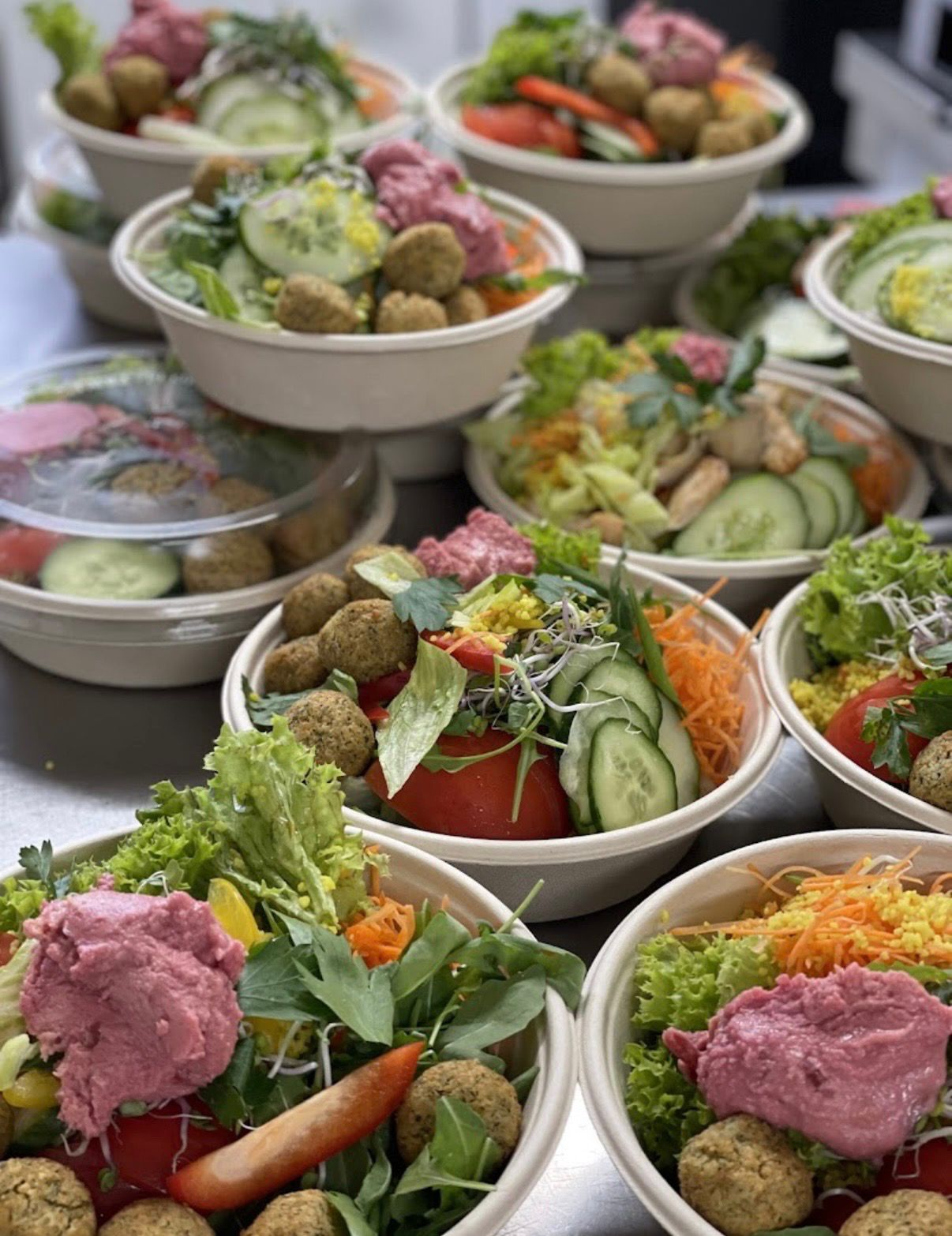 Mehrere frisch angerichtete Salat-Bowls für ein Catering